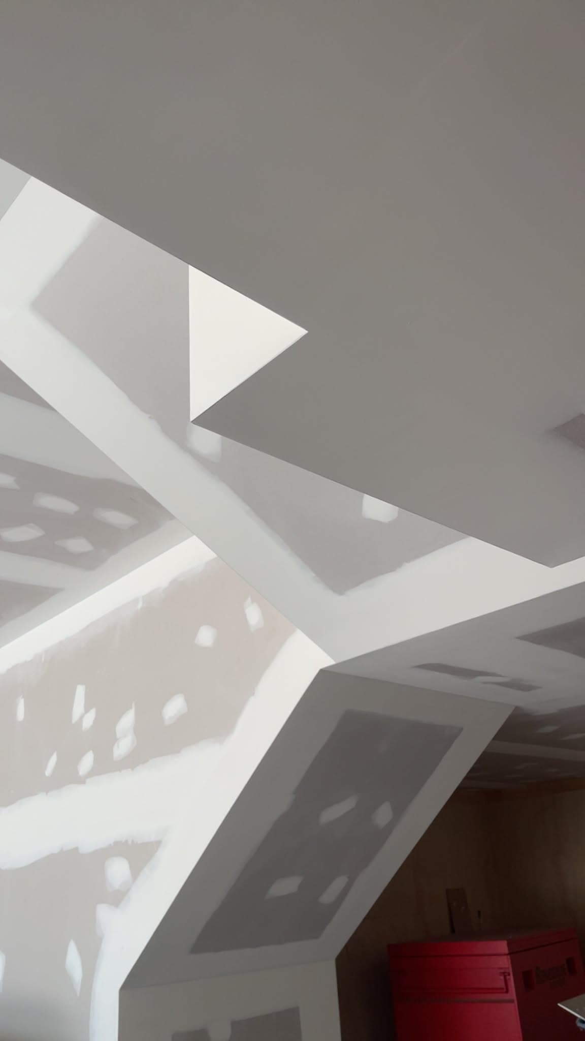 Joint compound feathered out across a complex ceiling with soffits and angles