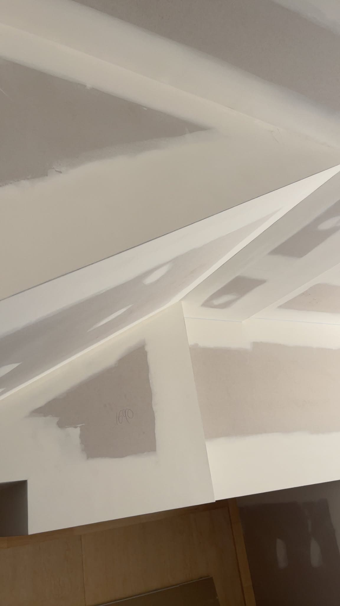 Compound coats mid-process on a raked ceiling with bulkheads and soffits
